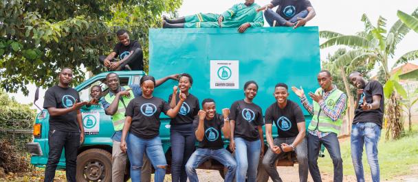 Yo-Waste workers pose in front of a garbage collection vehicle.