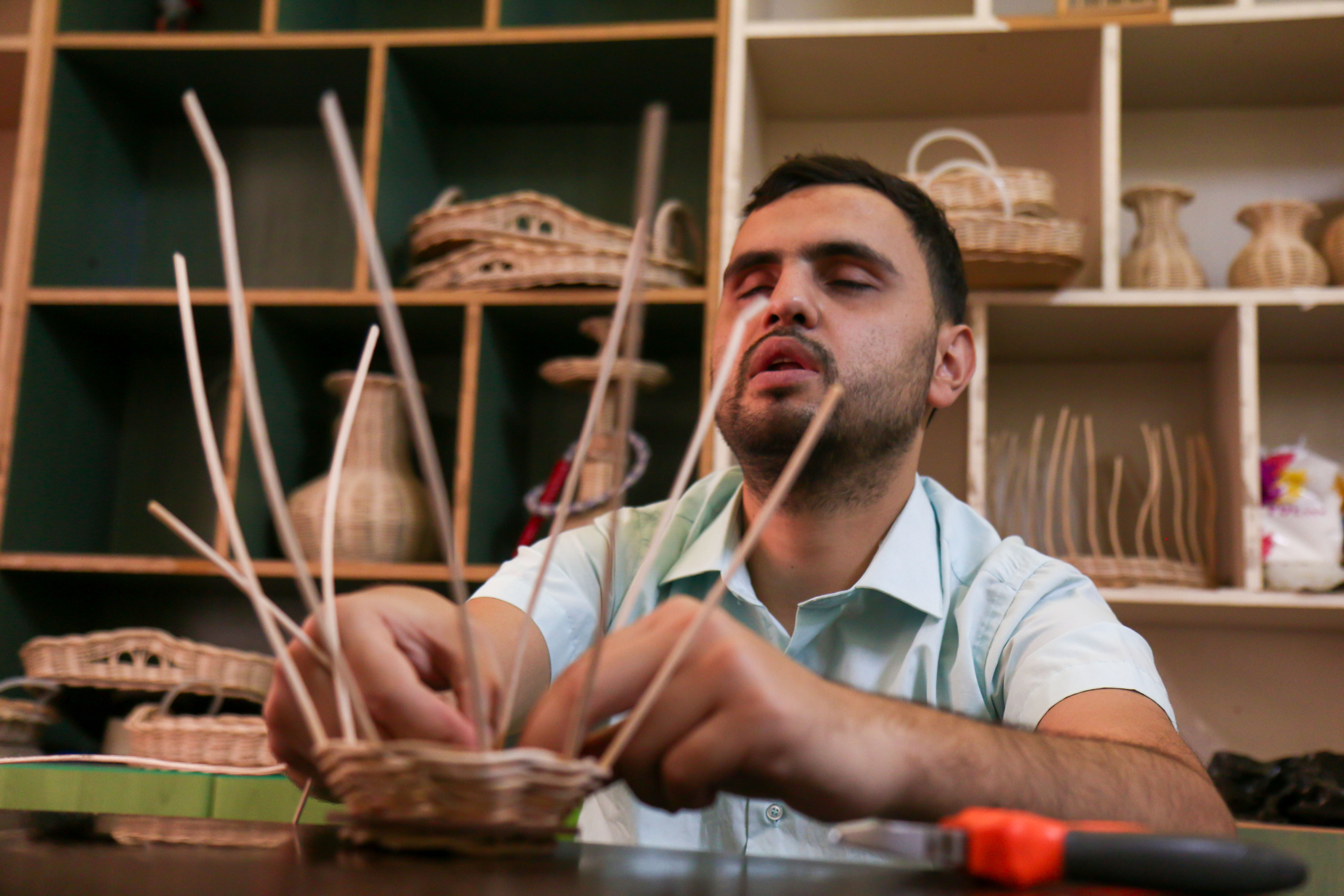 A young man with seeing difficulty from Idlib, Syria is sewing a basket. His craft is displayed at the Craft Exhibition for the Blind organized by the Shafak Organization's Makani Community Center. 