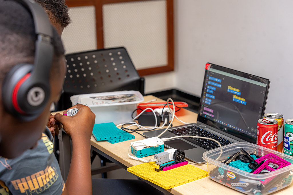 a boy sitting at a desk with a computer on a table