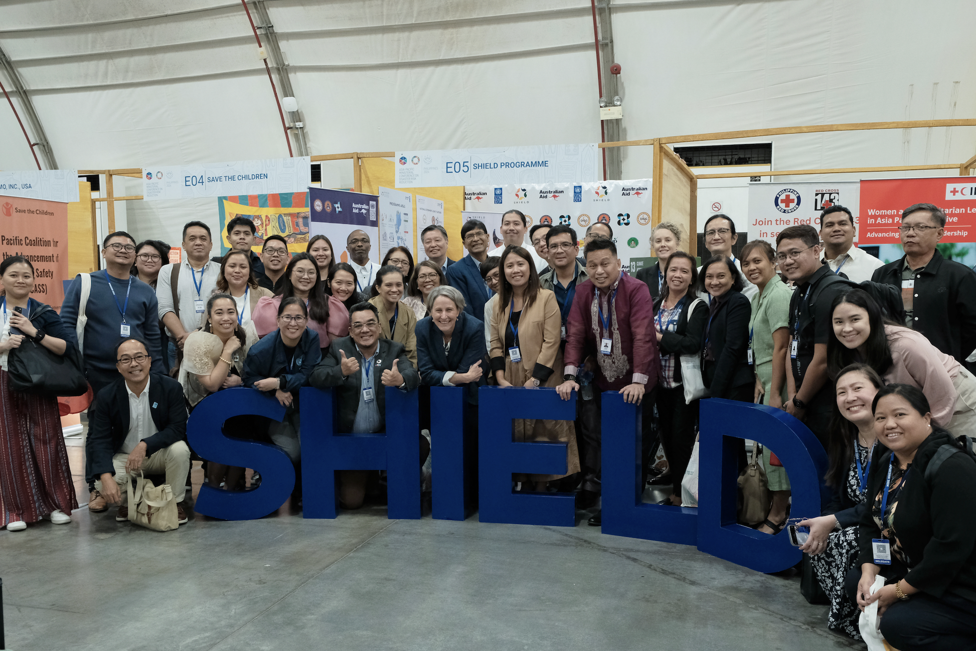 a group of people standing in front of a crowd posing for the camera