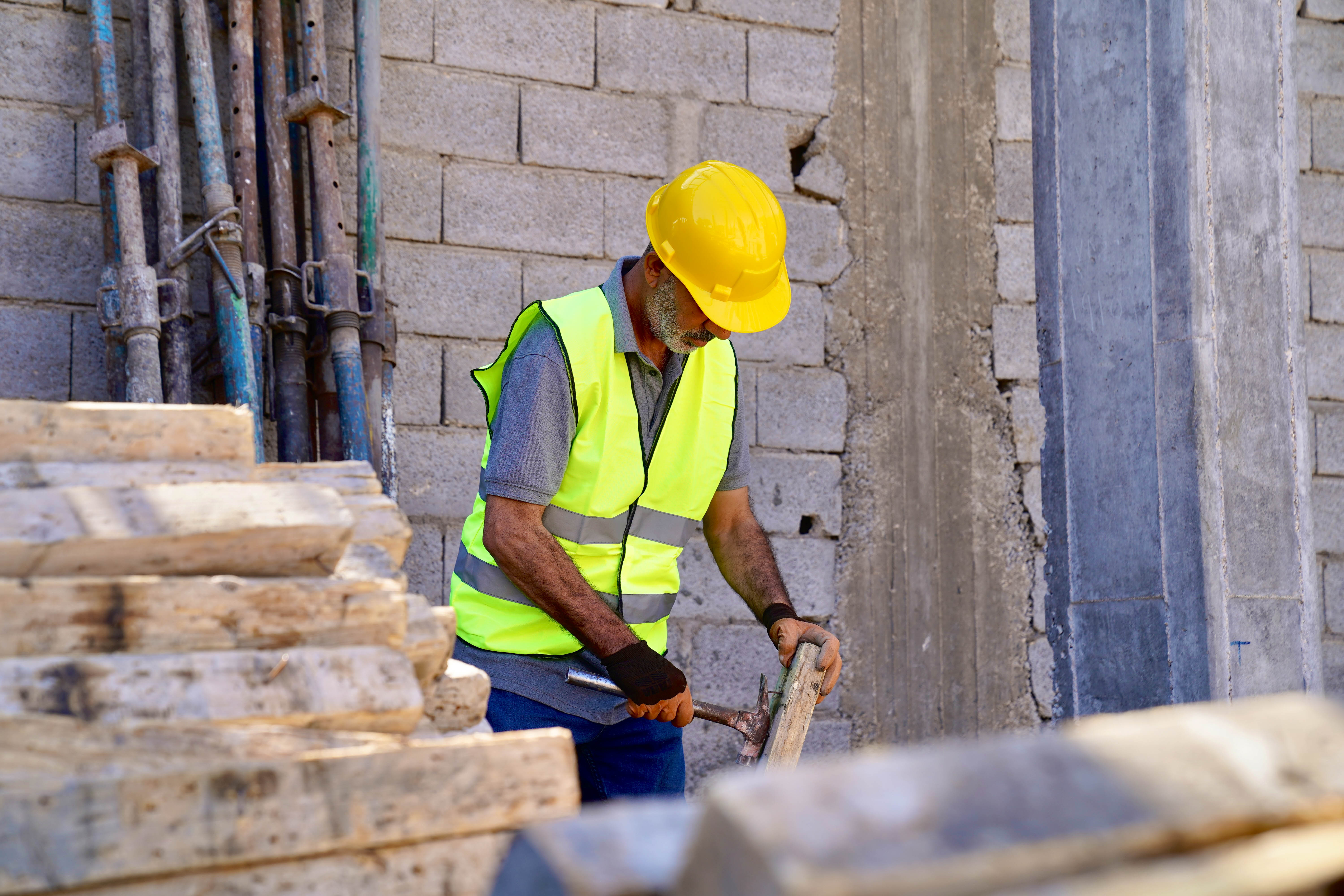 building,outdoor,man,holding,banana,wooden,board,standing,brick,hat,table,cutting,street