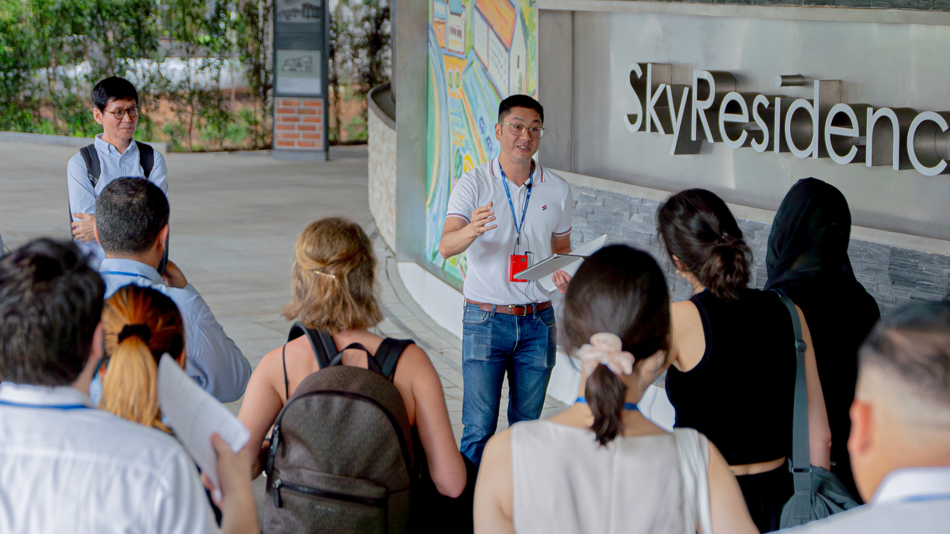 A guide explaining to a group of people at a visit to The Sky Residence