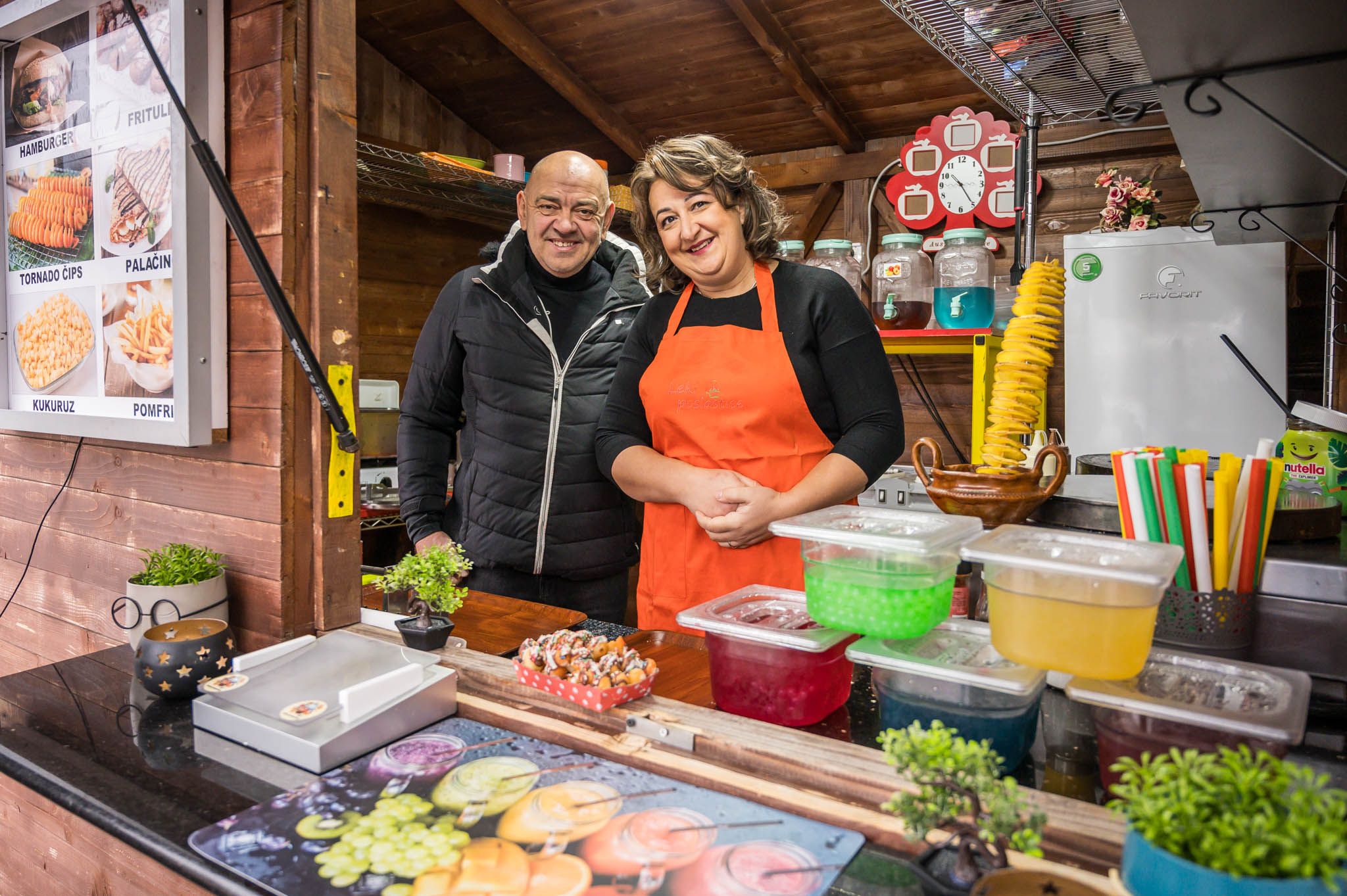 a man and woman preparing food on a table