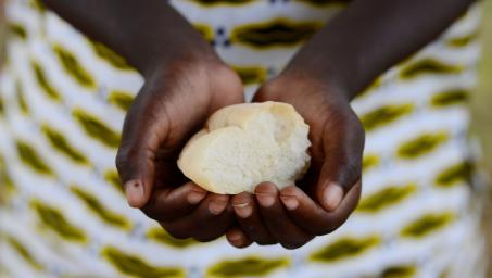 Hands of African woman holding wheat-based food ball