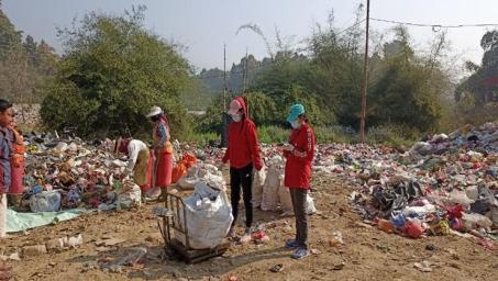 Two ladies sorting and weighing waste at a collection center